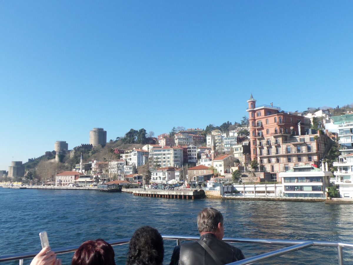 Private Bosphorus Cruise Yacht - views of the European shore from the water with few people on the boat